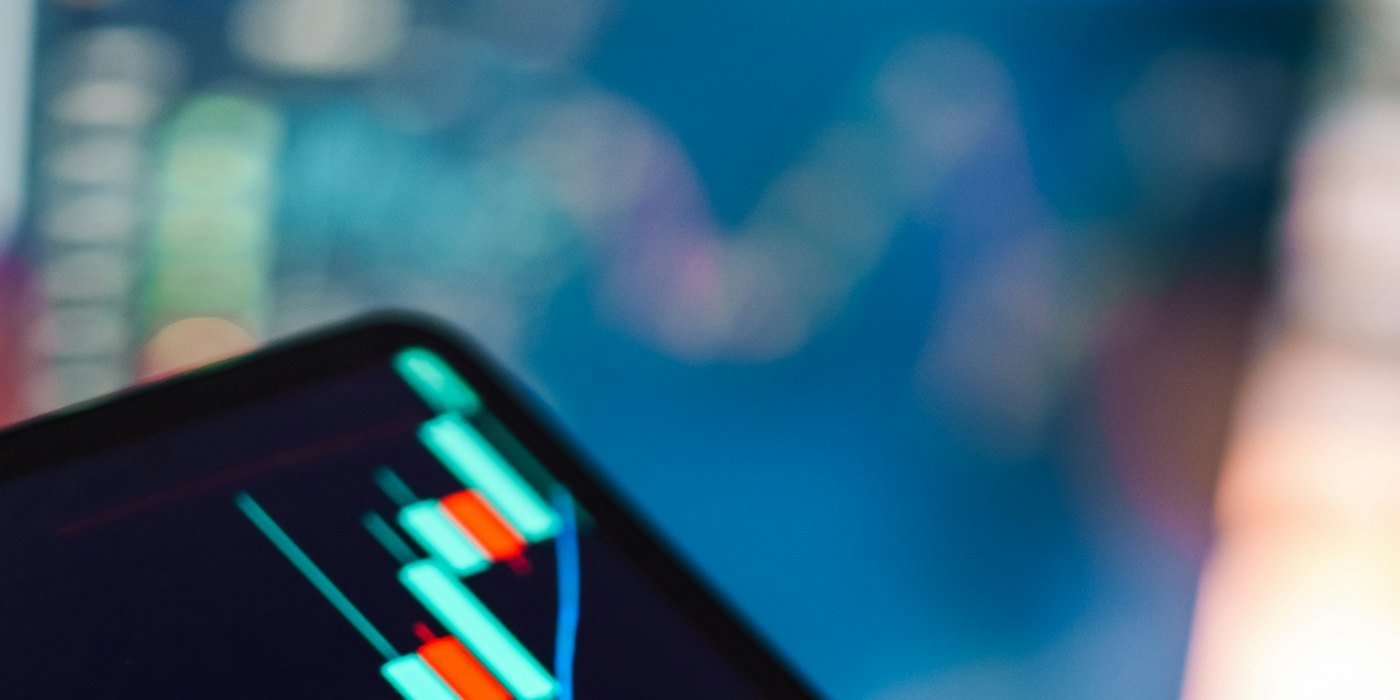 Tableta de mano que muestra el gráfico de velas del mercado bursátil — Antes de invertir: los 5 requisitos que debes cumplir