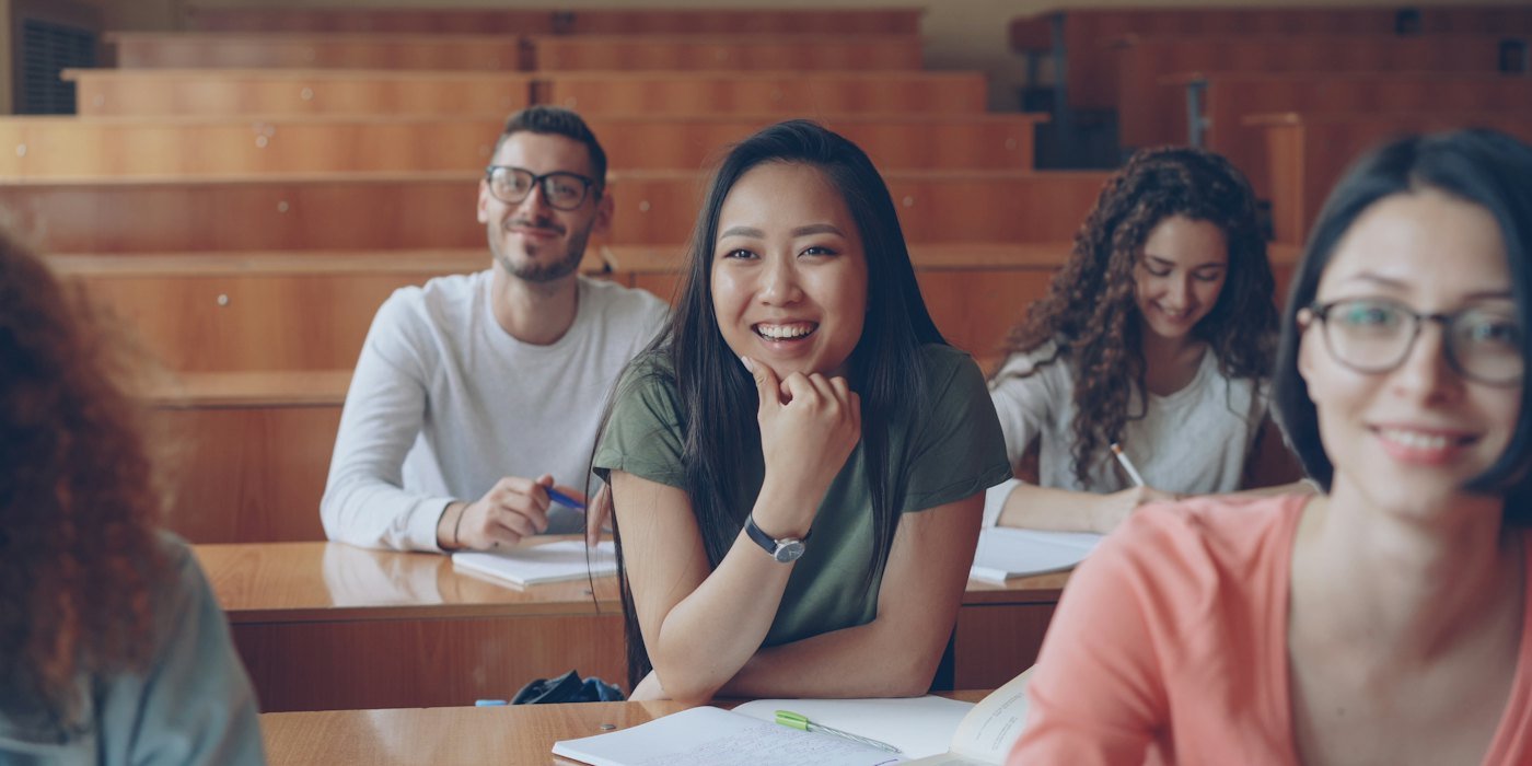 Estudiantes sonriendo en un aula de la sala de conferencias — Ayudas para emprender siendo joven