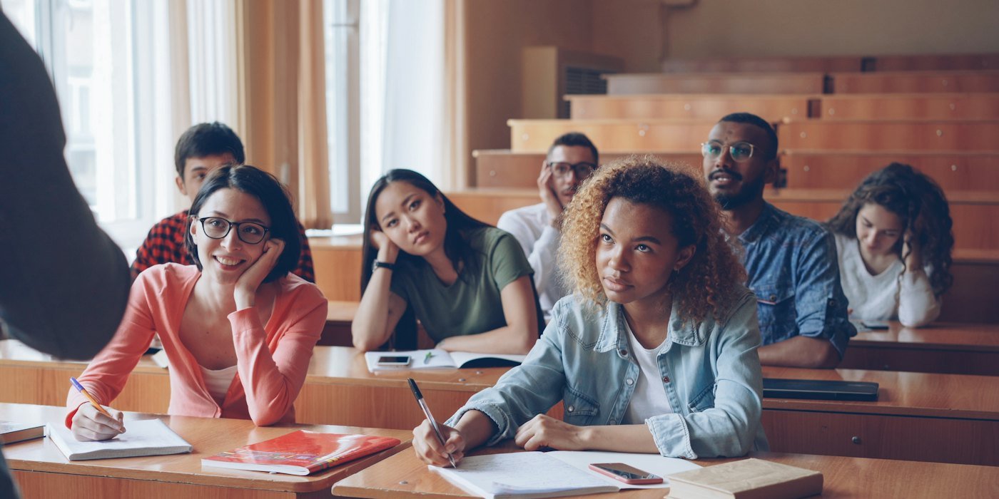 Estudiantes escuchando atentamente en una sala de conferencias — Ayudas para la compra de vivienda joven