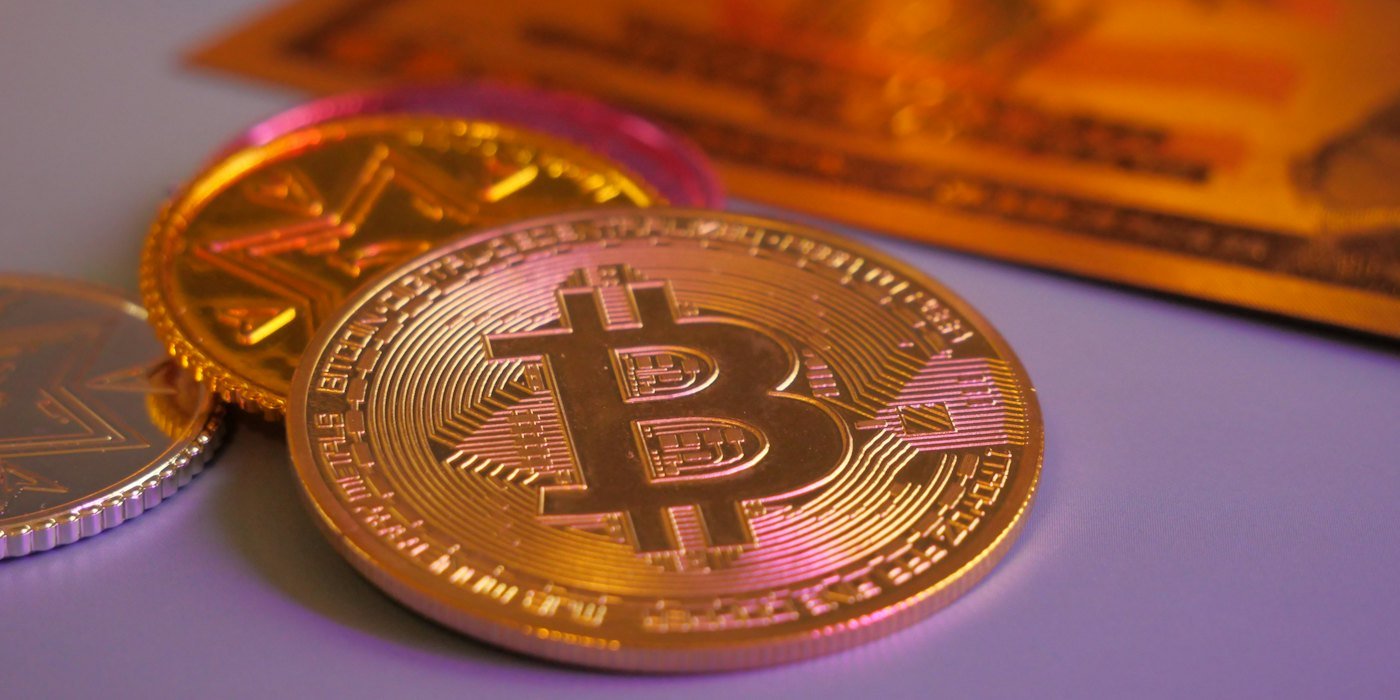 Moneda bitcoin dorada con otras monedas y tarjeta — Bitcoin: qué es y cómo funciona