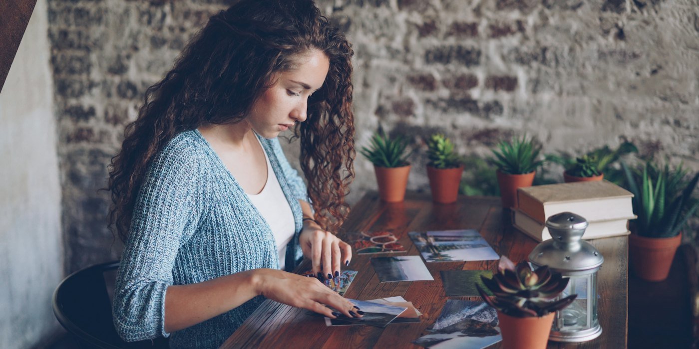 Mujer mirando las cartas del tarot en una mesa de madera — Bruto, neto, nominal y real: cuatro palabras que confunden