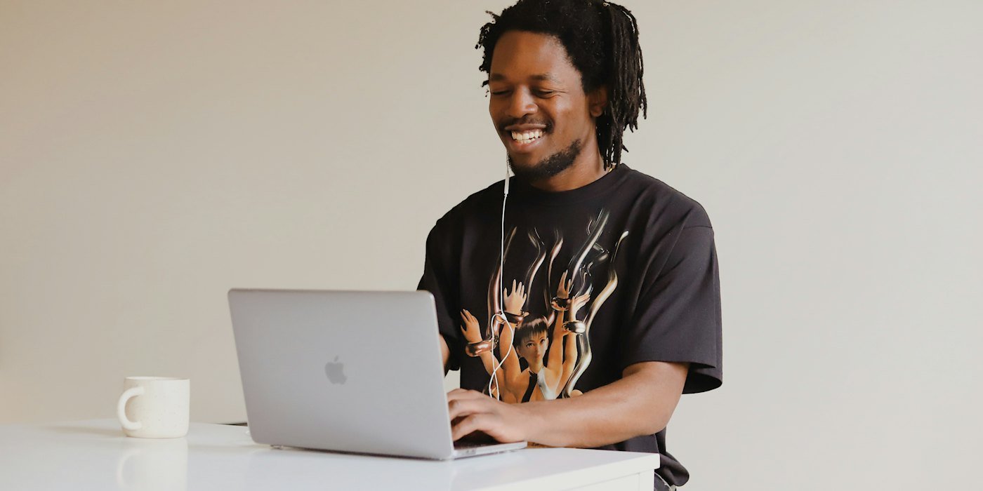 Hombre en camiseta negra de cuello redondo usando MacBook — Cambiar de trabajo para cobrar más: cuándo merece la pena