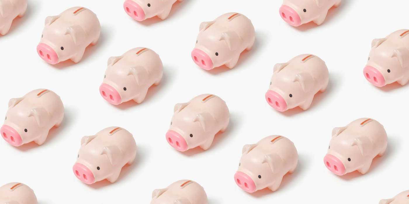 Un grupo de pequeñas figuritas de cerdo rosa sobre una superficie blanca — Cómo ahorrar para la entrada de un piso