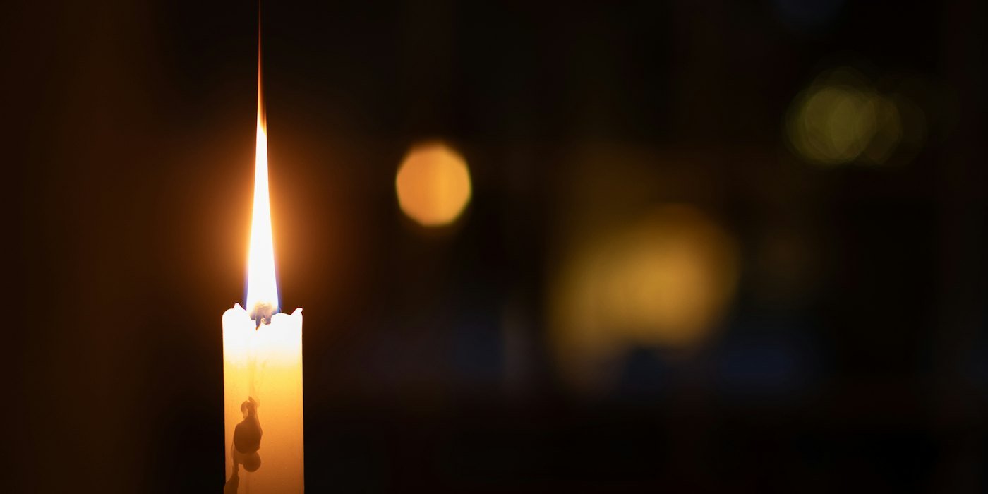 Una sola vela encendida brilla en la oscuridad — Cómo comprar un ETF paso a paso
