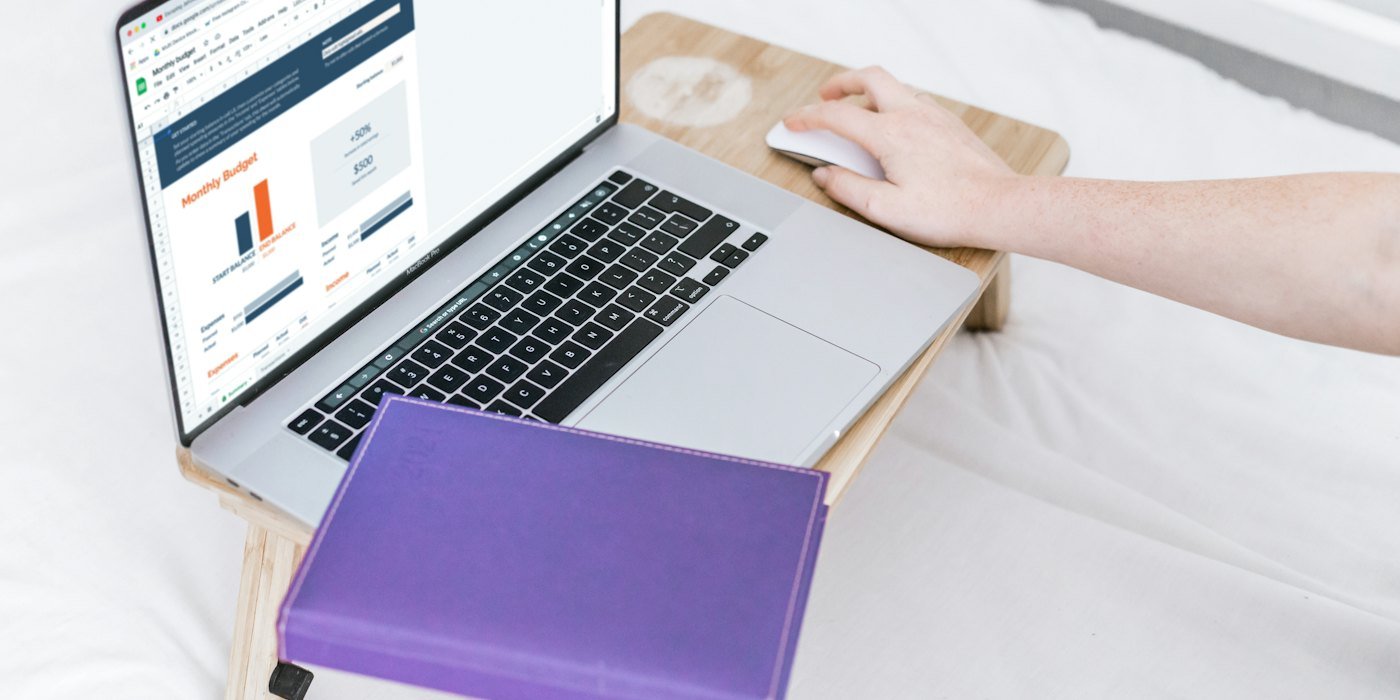 una persona que usa una computadora portátil en una cama — Cómo registrar tus gastos sin agobiarte
