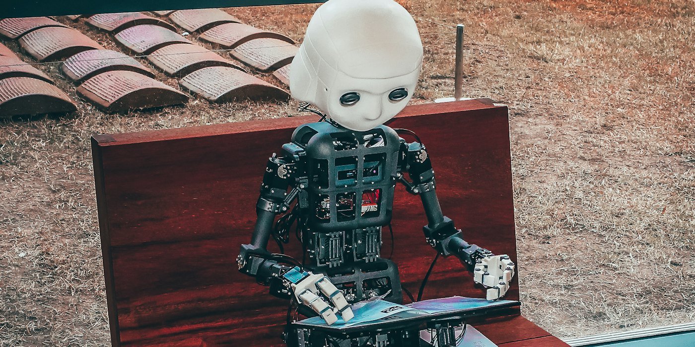 juguete robot blanco y negro sobre mesa de madera roja — Cómo usar la IA para buscar trabajo y preparar entrevistas