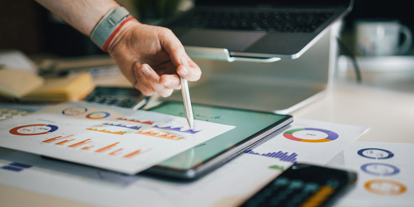 Persona usando lápiz en tableta con gráficos — Cuándo endeudarse puede tener sentido