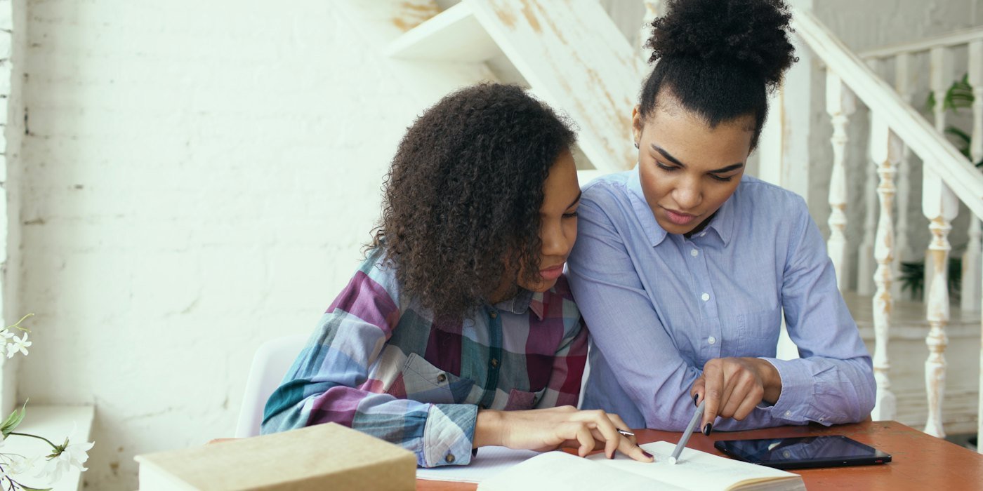 Madre e hija estudiando juntas en una mesa — Cuánto dinero deberías tener ahorrado a los 25 años