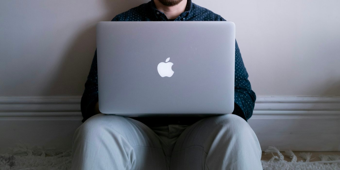 Un hombre sentado frente a una computadora portátil — Dar clases particulares: cómo empezar y cuánto cobrar