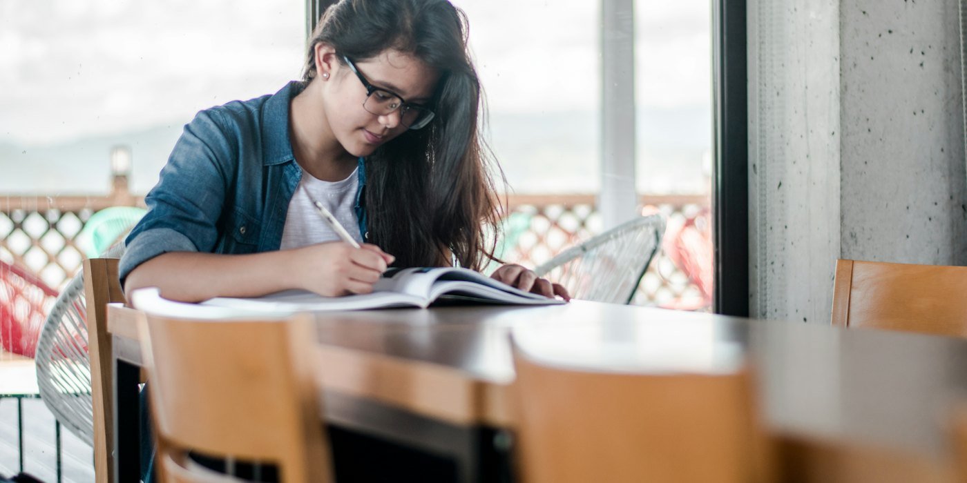 woman writing on book — Descuentos y carnés para jóvenes: Carné Joven europeo