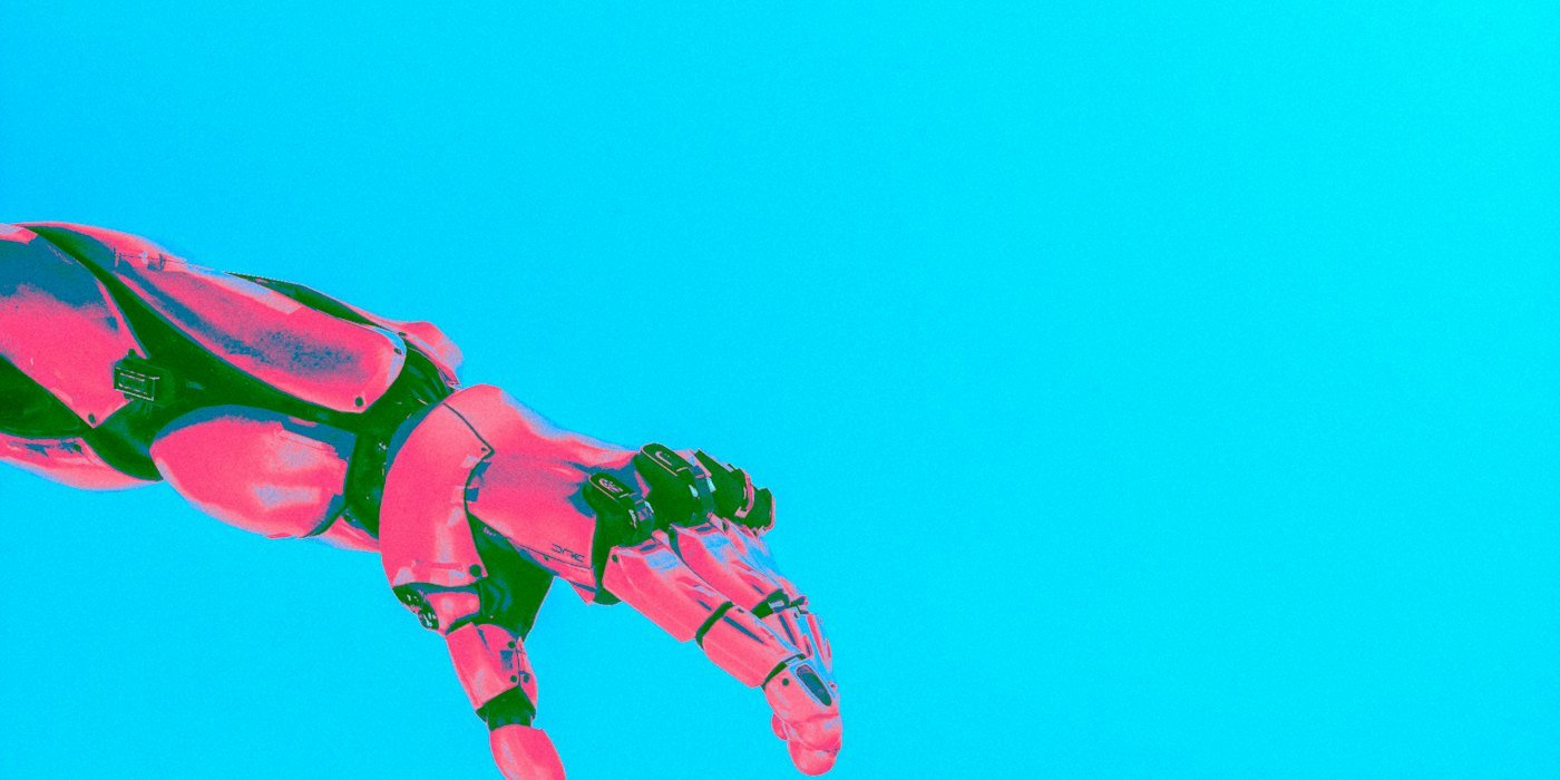 Manos robóticas y humanas extendiéndose una hacia la otra — Estafas con inteligencia artificial: deepfakes y voces clonadas