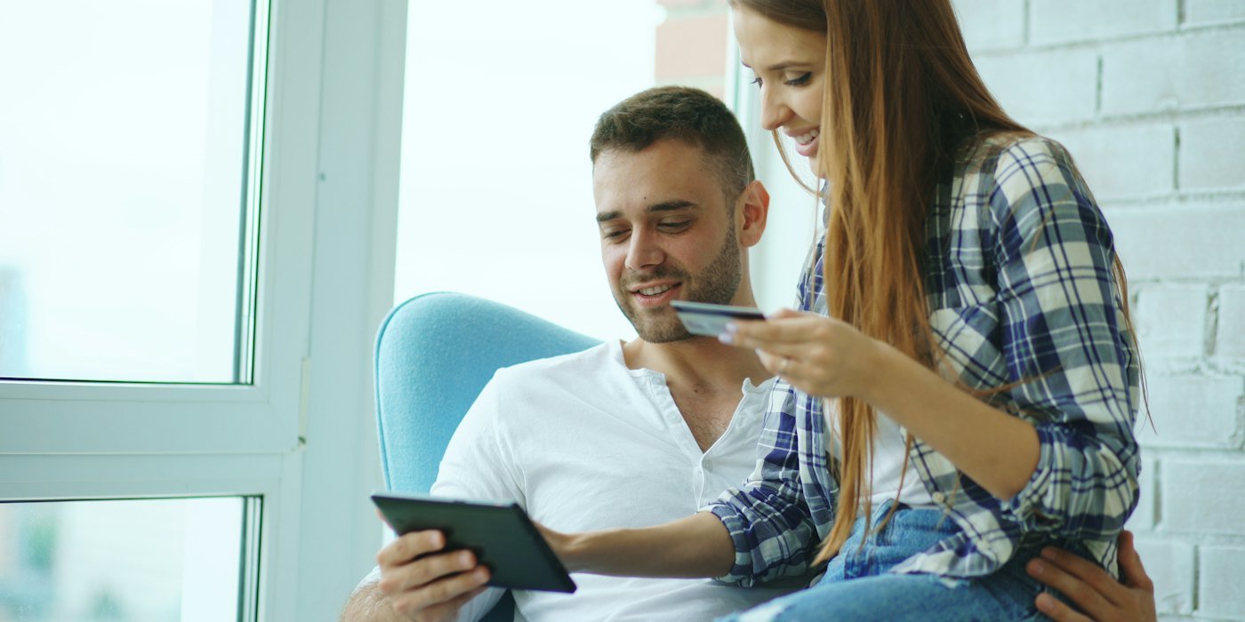 Pareja felizmente comprando en línea con tableta y tarjeta de crédito — Finanzas a los 18 años: lo que nadie te explica