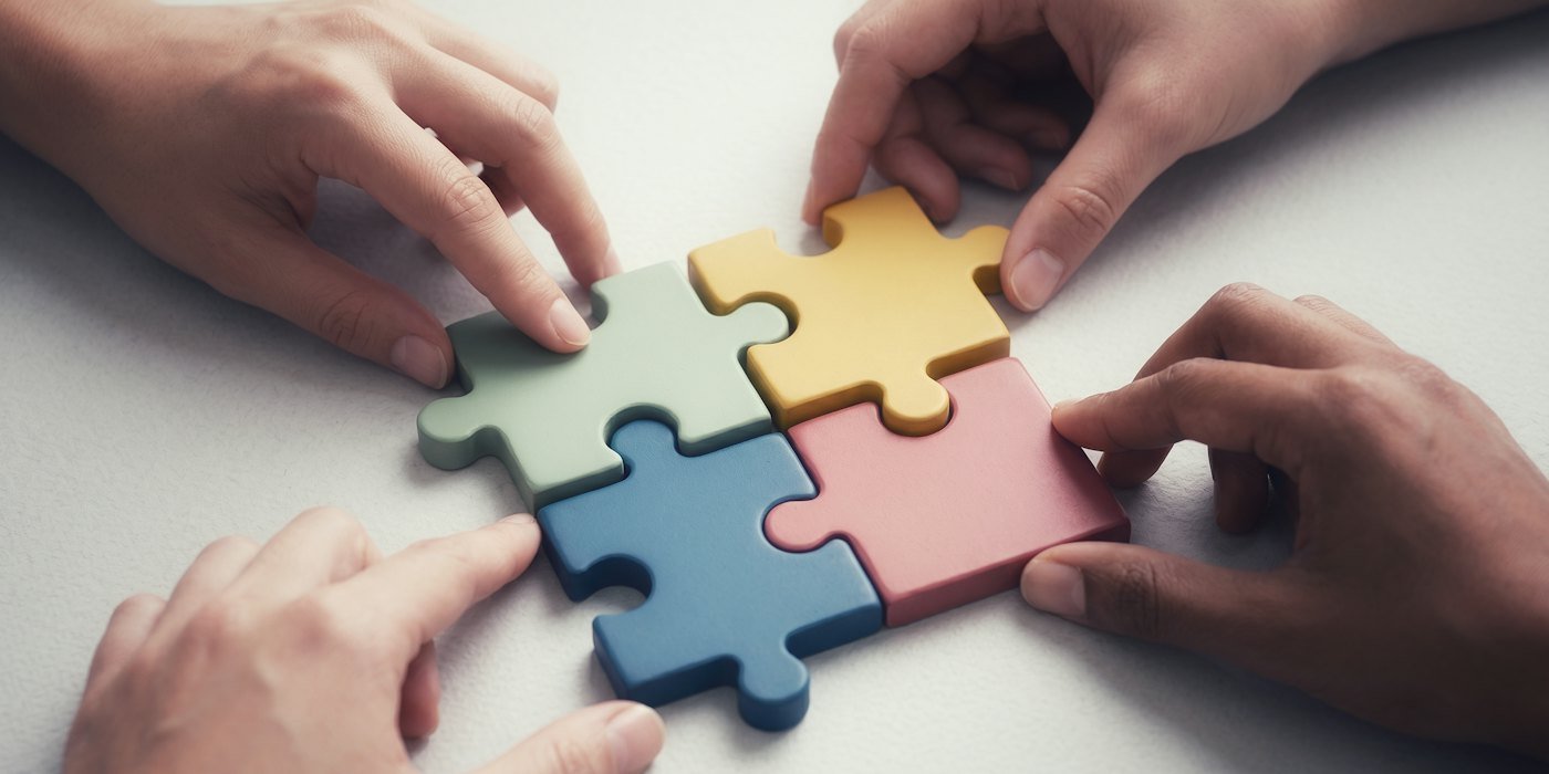Manos conectando piezas coloridas del puzle — Fondos factoriales: value, calidad, momentum y tamaño