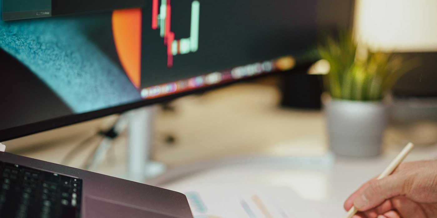 una persona escribiendo en una hoja de papel junto al monitor de una computadora — Fondos perfilados y fondos de fondos