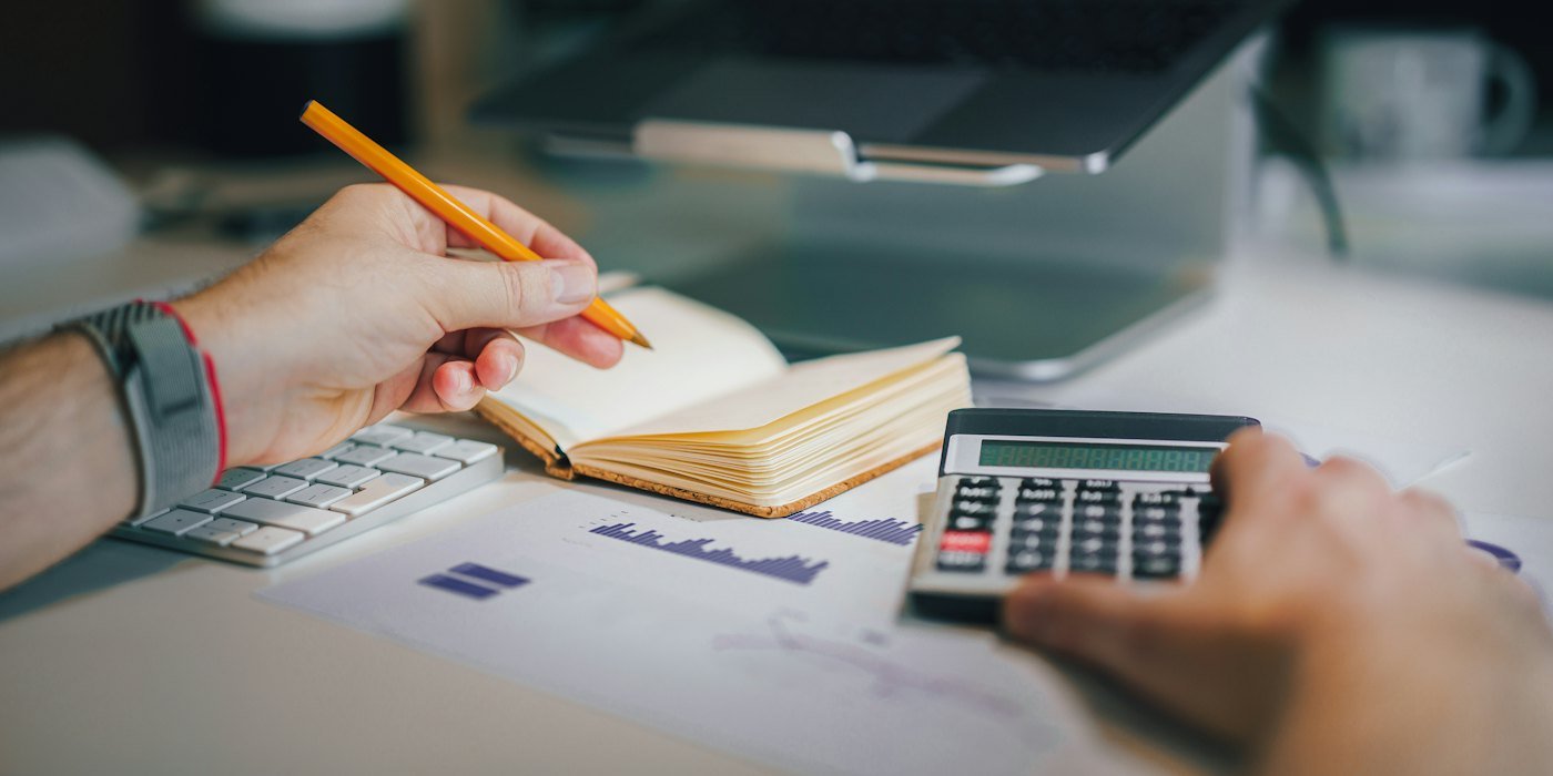 una persona sentada en un escritorio con una calculadora y un cuaderno — Interés simple e interés compuesto: la diferencia que lo cambia todo