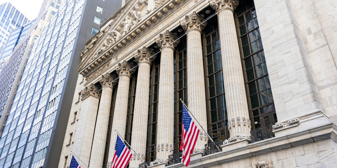 Edificio de la bolsa de valores de Nueva York con banderas estadounidenses — Invertir en acciones de Estados Unidos desde España
