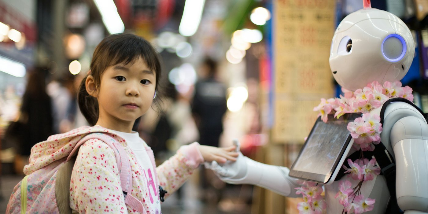Foto de la niña que pone la mano izquierda en un robot digital blanco — La IA en tu banco: cómo te afecta