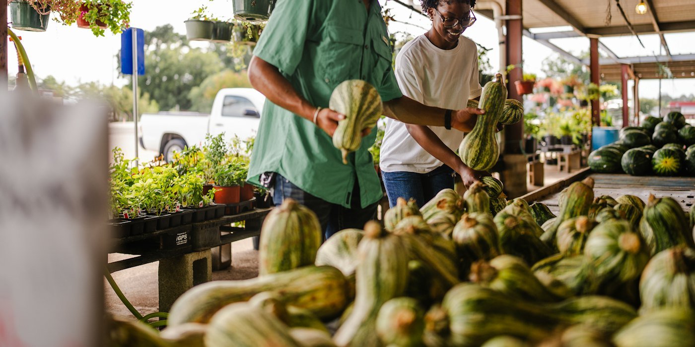 Pareja comprando calabazas en un mercado al aire libre — Minimalismo financiero: gastar en lo que de verdad importa