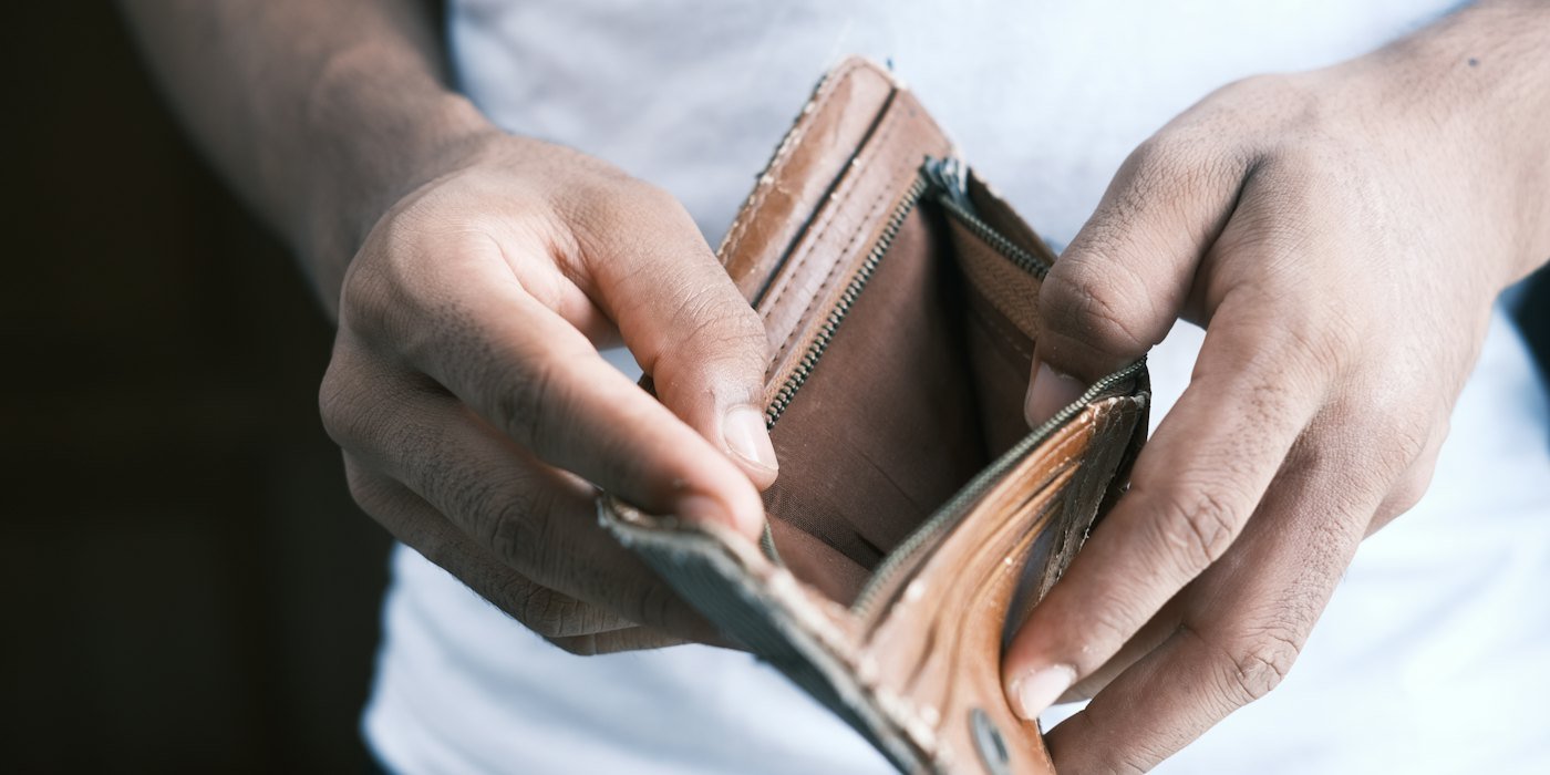 Persona sosteniendo una billetera plegable de cuero marrón — Prestar dinero a amigos o familia sin perder la relación