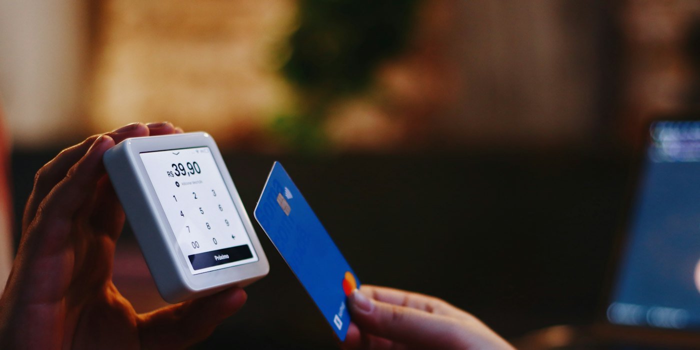 una persona con una tarjeta de crédito y un teléfono celular — Productos vinculados: qué son y cómo evitarlos