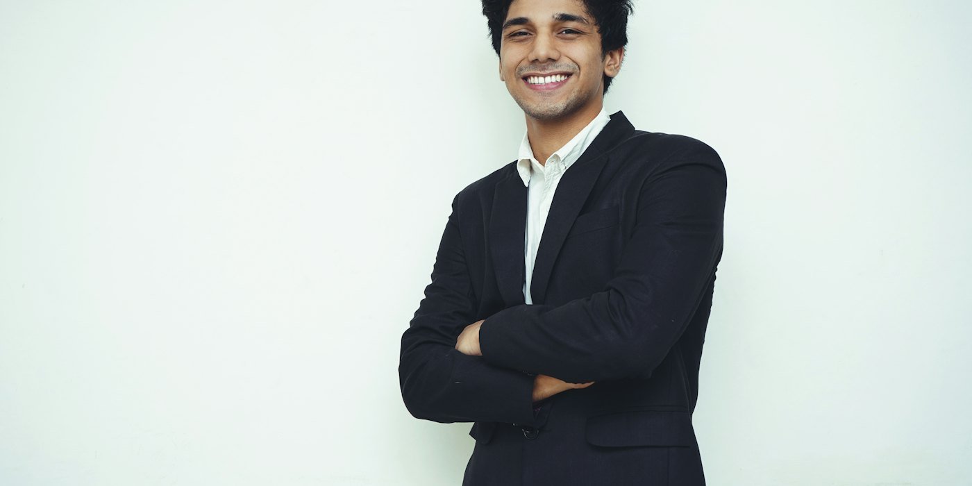 hombre en chaqueta de traje negro sonriendo — Teletrabajo: gastos y derechos