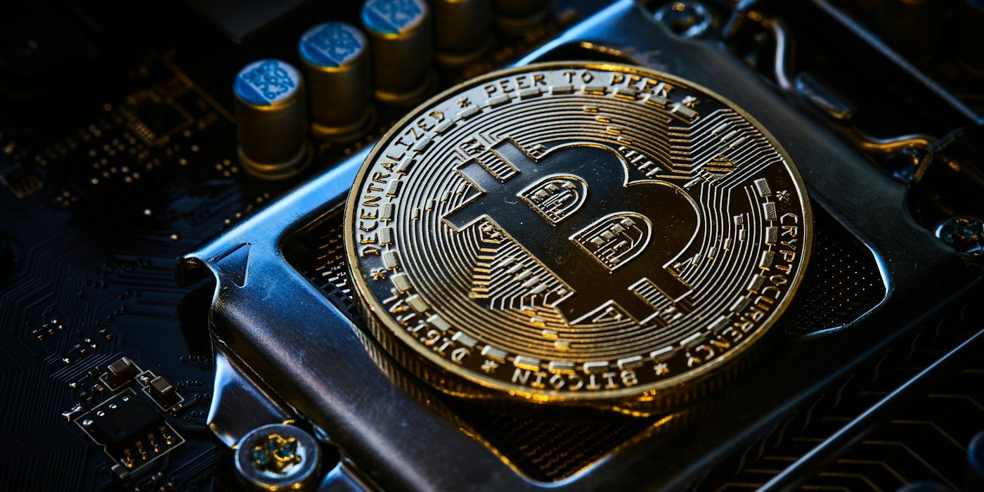 Un bitcoin encima de la placa base de una computadora — Wallets: custodia propia o de un tercero